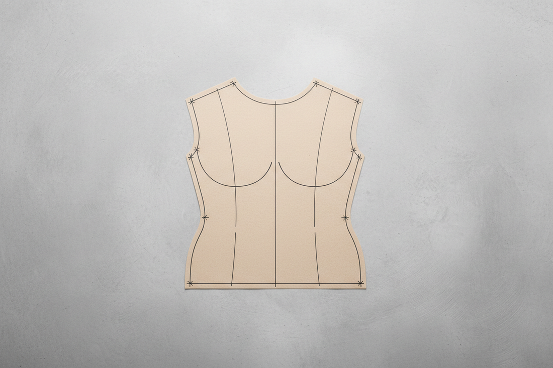 Bodice block pattern piece showing dart lines and construction markings on work surface for pattern-making fundamentals