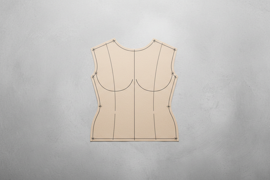 Bodice block pattern piece showing dart lines and construction markings on work surface for pattern-making fundamentals