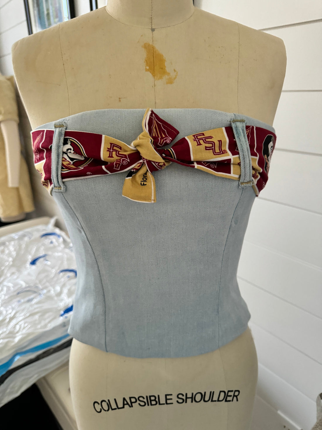 Finished denim corset with FSU bow tie on dress form