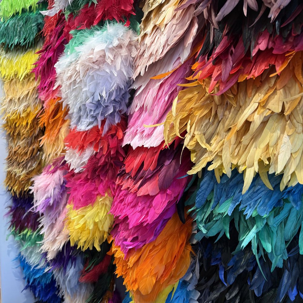 Rows of brightly coloured feather boas hanging in a Soho trimmings shop