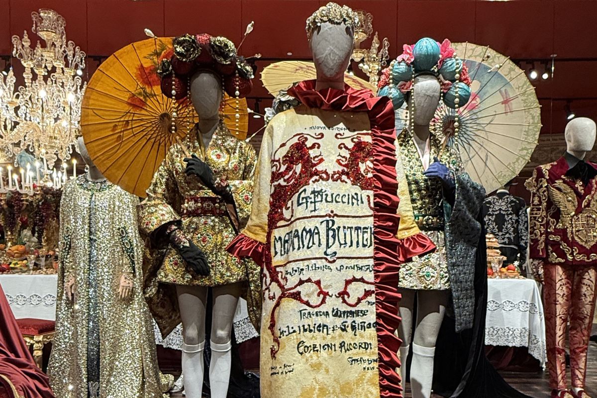 Mannequins in heavily embellished gold and red opera-inspired looks with parasols and floral headdresses, featuring a Madama Butterfly print dress at the Dolce & Gabbana museum, Miami
