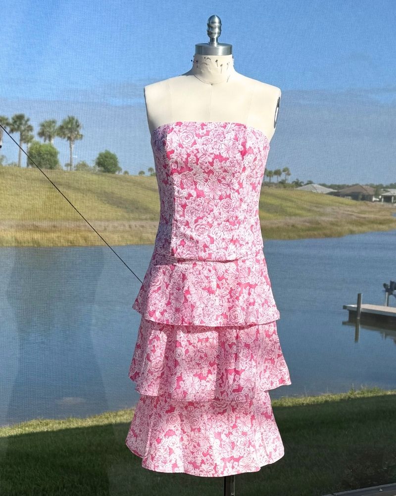 Pink strapless tiered floral dress on dress form outdoors, made by Nicola Grayling at the Fashion Institute of Florida
