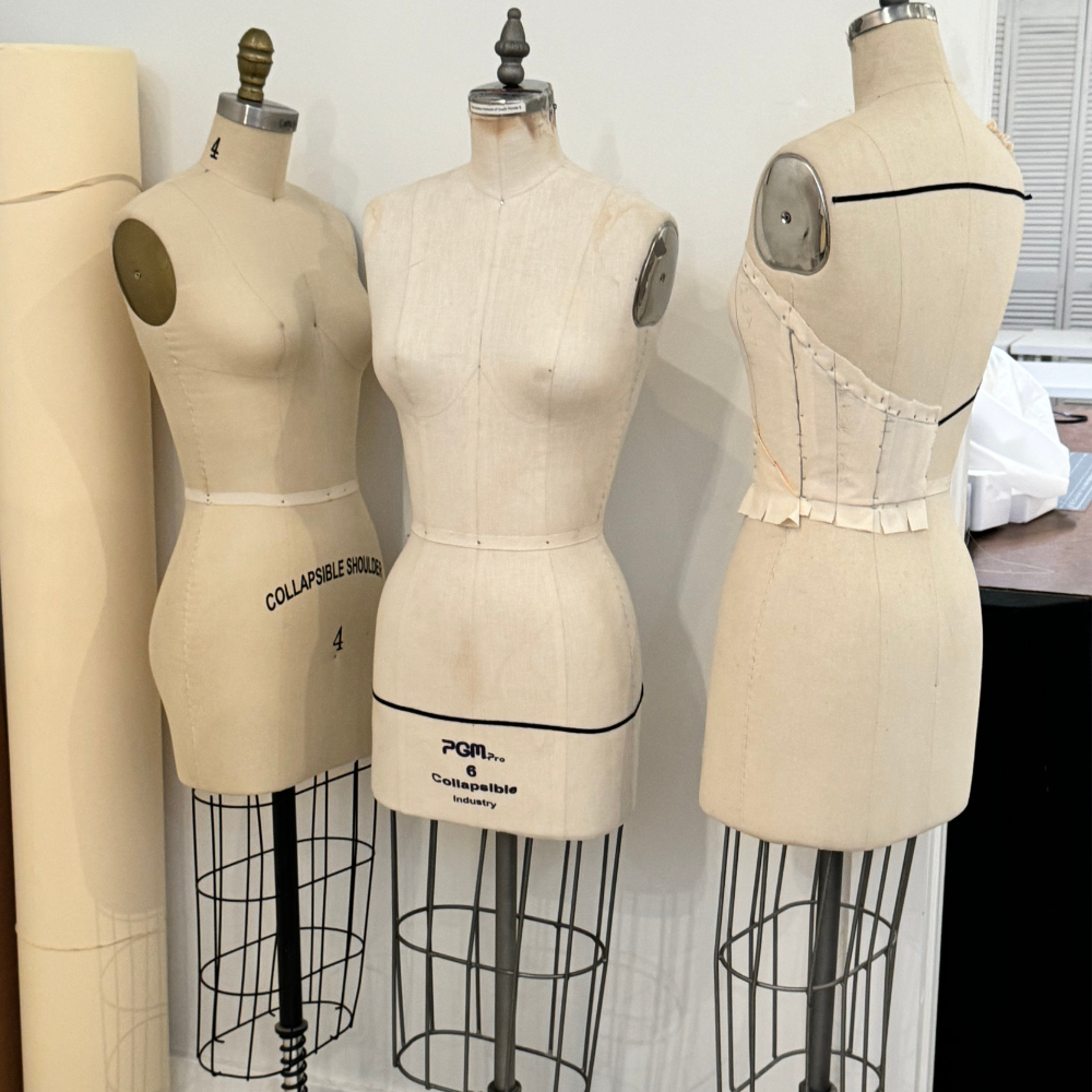 Fit and alterations shown through multiple dress forms used for garment fitting, proportion adjustments, and tailoring.