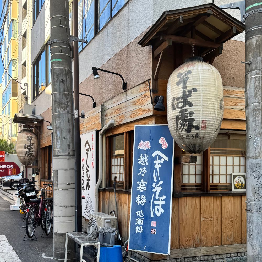 Japanese street scene with traditional soba restaurant paper lanterns and wooden shopfront — After Stilettos Japanese Kimono
