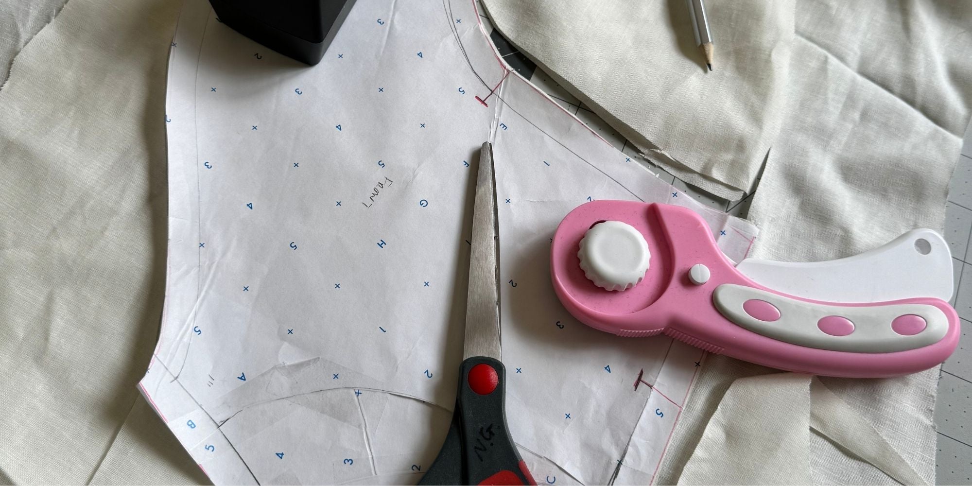 Dressmaking pattern pieces with scissors and rotary cutter on the cutting table — After Stilettos pattern making process