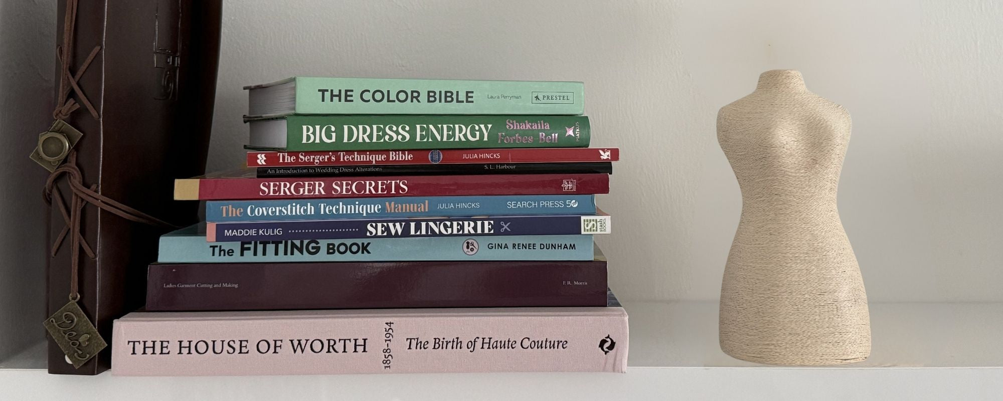 Stack of sewing and fashion books including The House of Worth and Big Dress Energy beside a dress form — After Stilettos atelier library