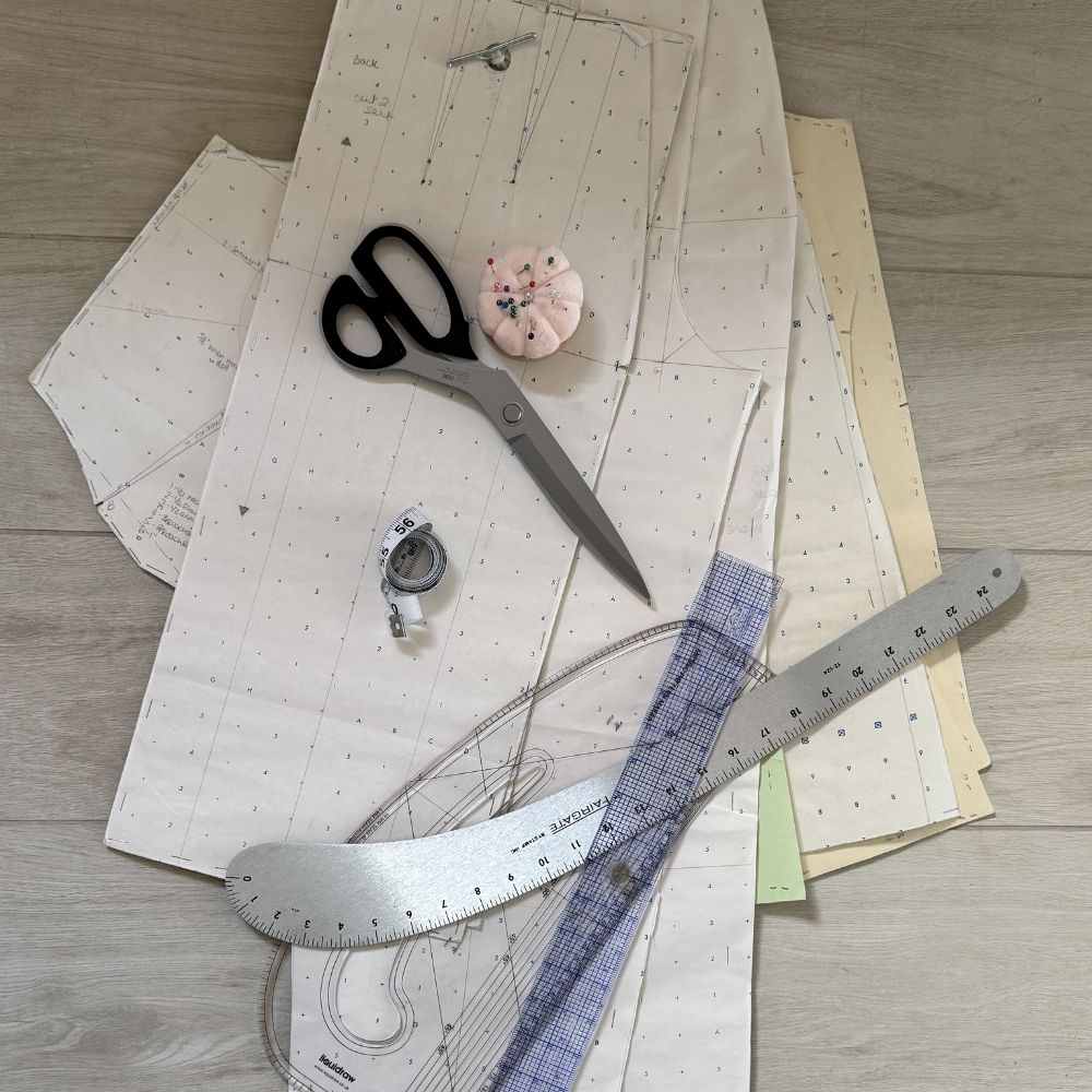 Dressmaking pattern pieces with scissors, pin cushion, French curve ruler and tape measure flatlay — After Stilettos sewing and making