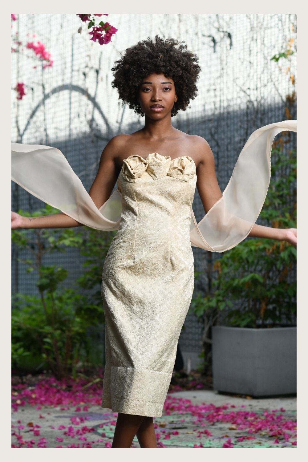 Model wearing Shadow Blossom ivory brocade strapless gown with sculptural rose bodice and flowing chiffon sleeves, After Stilettos evening wear
