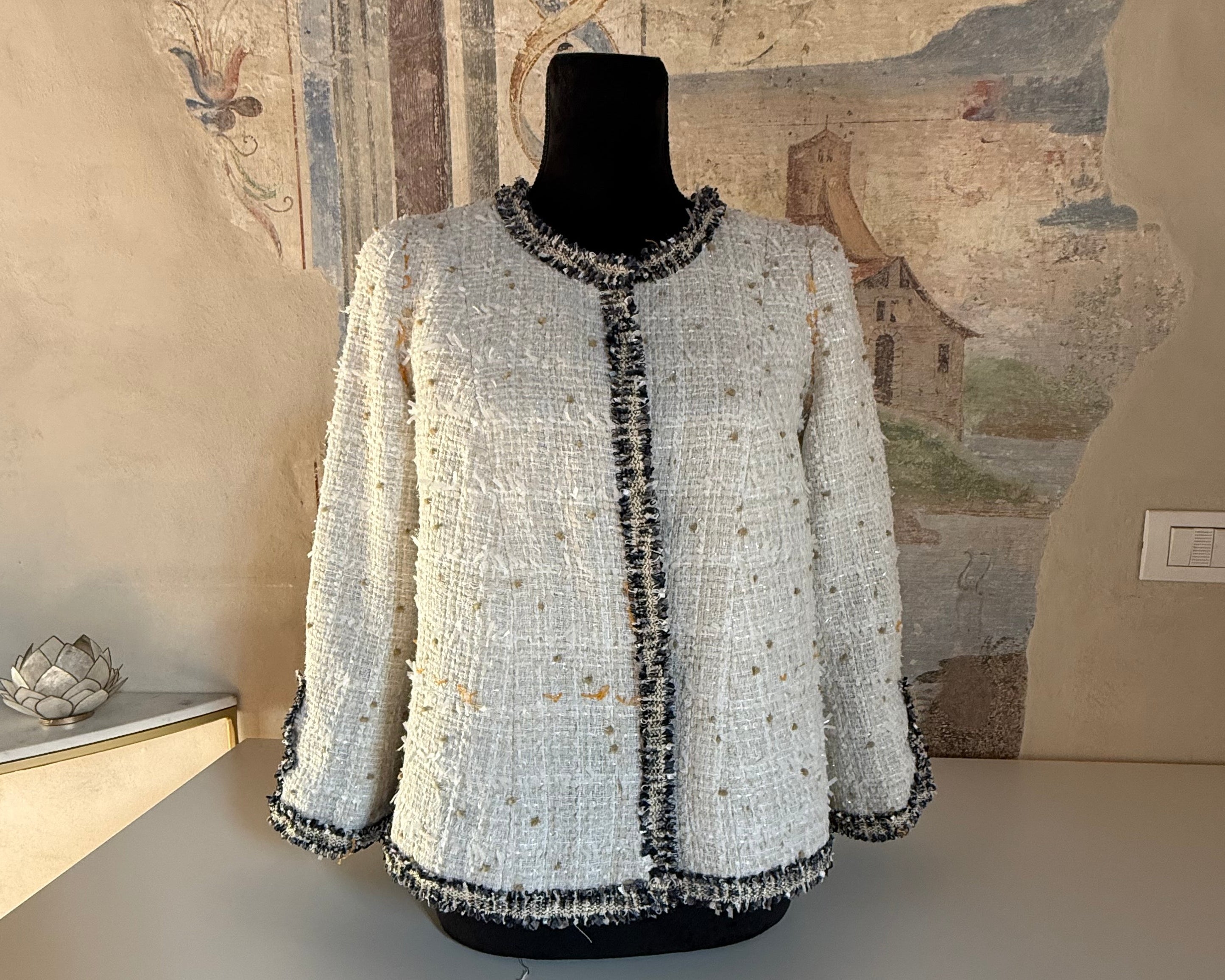 Handmade white beaded jacket on dress form showing couture construction and craftsmanship
